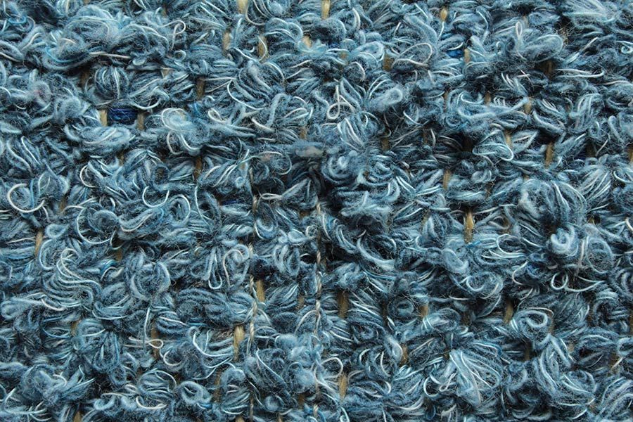 Eine Nahaufnahme der Struktur eines blauen Teppichs.