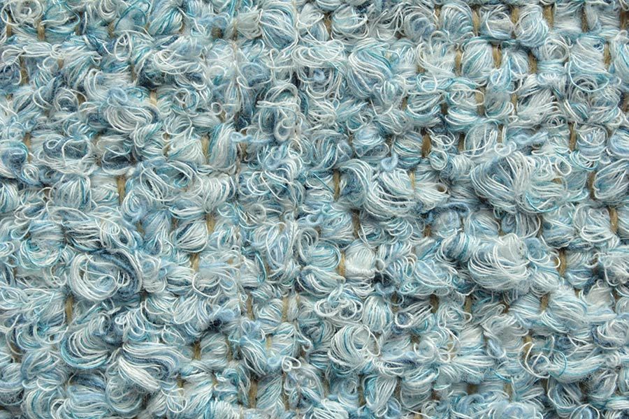 Eine Nahaufnahme eines hellblauen Strickstoffes.