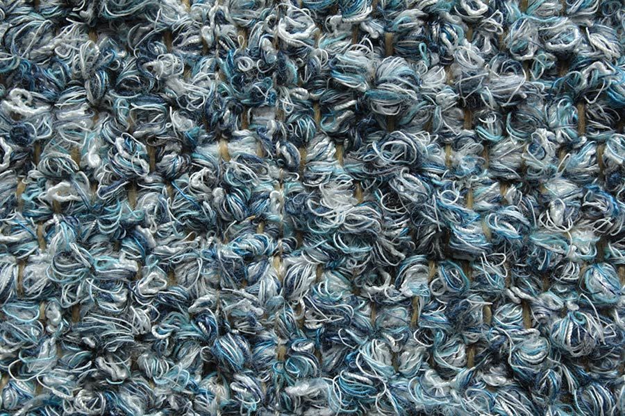 Eine Nahaufnahme der Struktur eines blauen Teppichs.