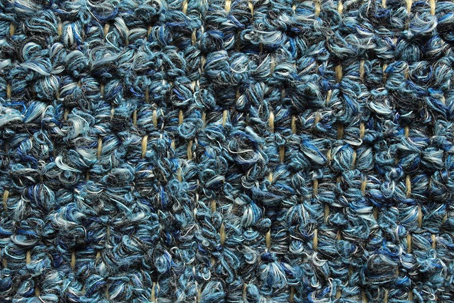 Eine Nahaufnahme eines blauen Teppichs mit Strickmuster.