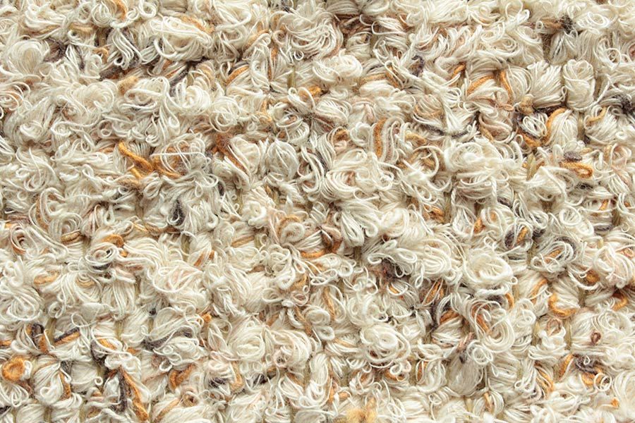 Eine Nahaufnahme eines Stapels weißen und braunen Teppichs.