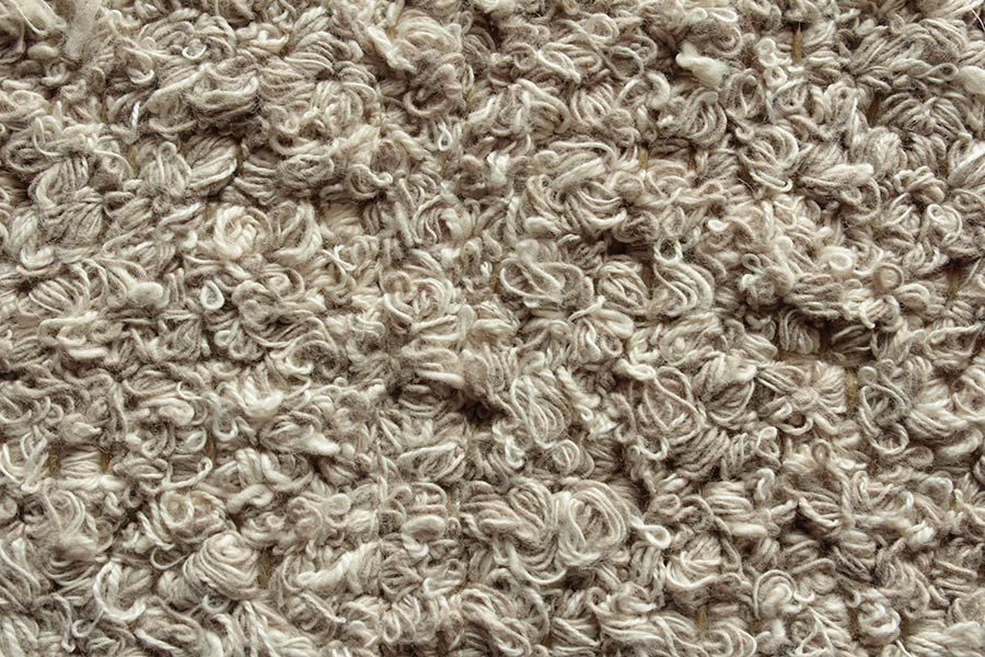Eine Nahaufnahme eines Garnhaufens auf einem Teppich.