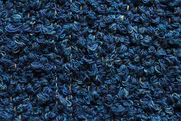Eine Nahaufnahme der Struktur eines blauen Teppichs.