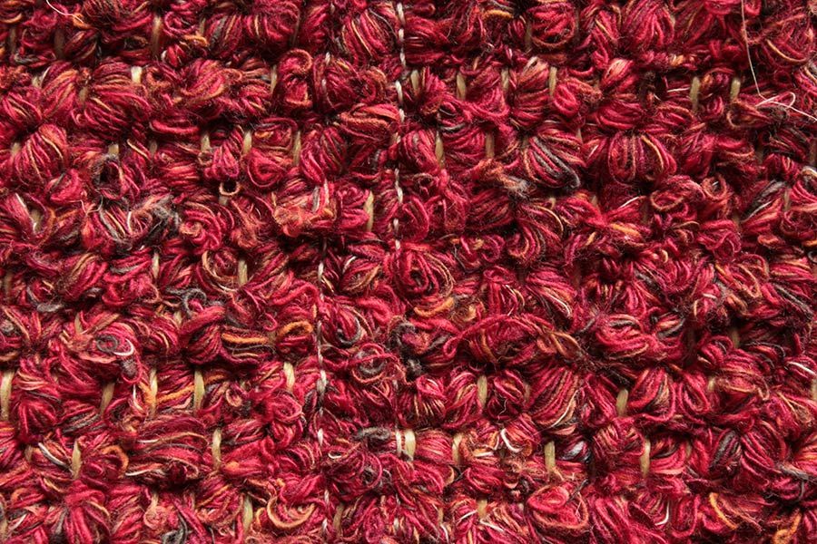 Eine Nahaufnahme eines rot-gelben Strickstoffes.