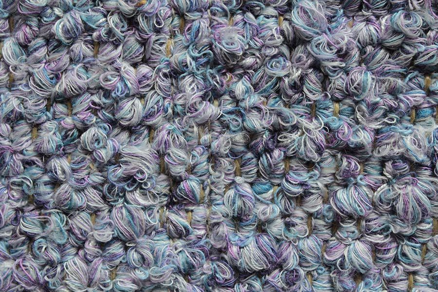 Eine Nahaufnahme eines Stapels aus lila und blauem Garn.