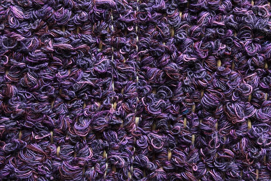 Eine Nahaufnahme eines violetten Strickstoffes.