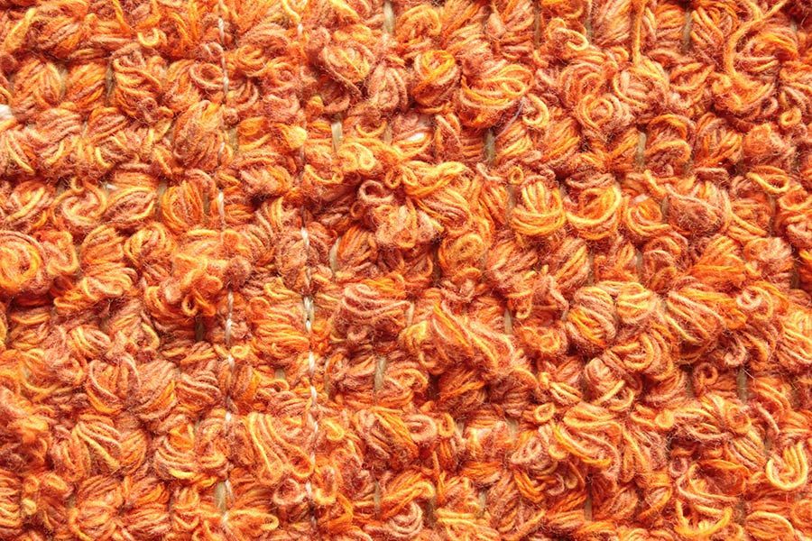 Eine Nahaufnahme eines Stapels orangefarbenen Garns.