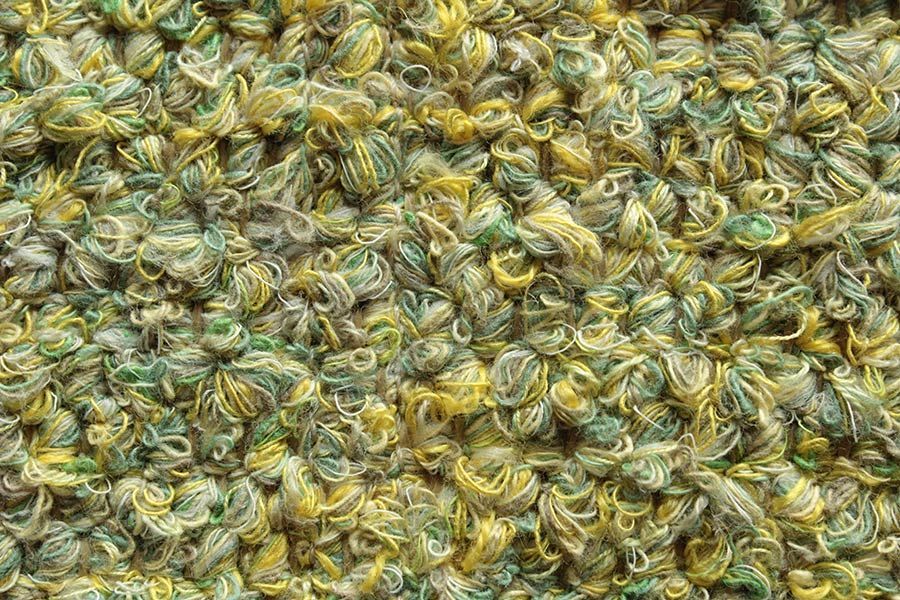 Eine Nahaufnahme eines Stapels aus grünem und gelbem Garn.