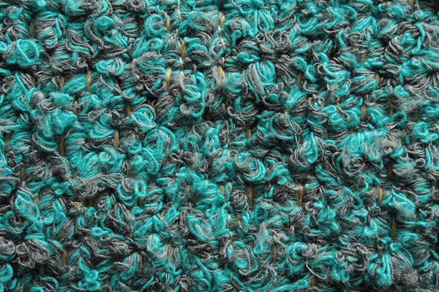 Eine Nahaufnahme eines blauen und grauen Teppichs.