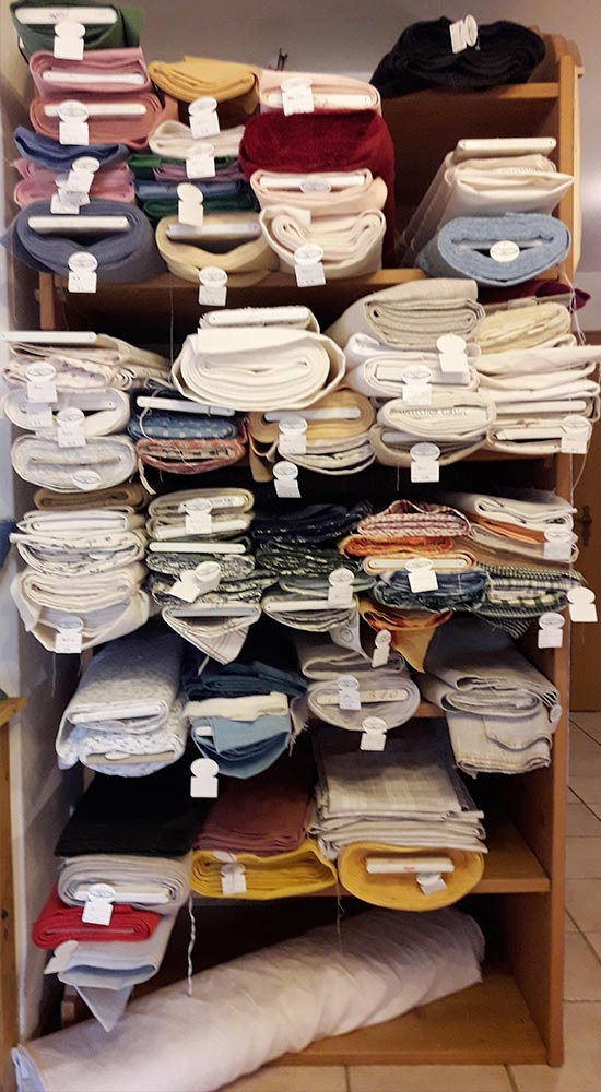 Ein Regal voller Stoffe in vielen verschiedenen Farben.