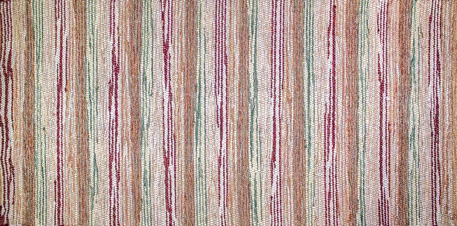 Eine Nahaufnahme eines gestreiften Teppichs mit violetten und grünen Streifen.