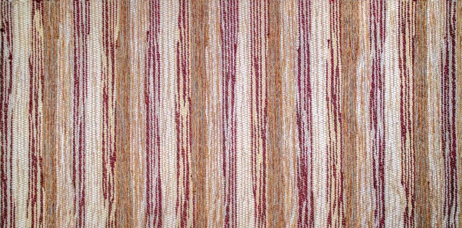 Eine Nahaufnahme eines braun und lila gestreiften Teppichs.