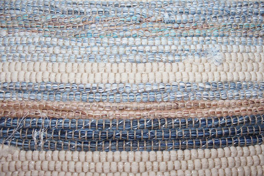 Eine Nahaufnahme eines blau-weißen Teppichs mit Streifenmuster.