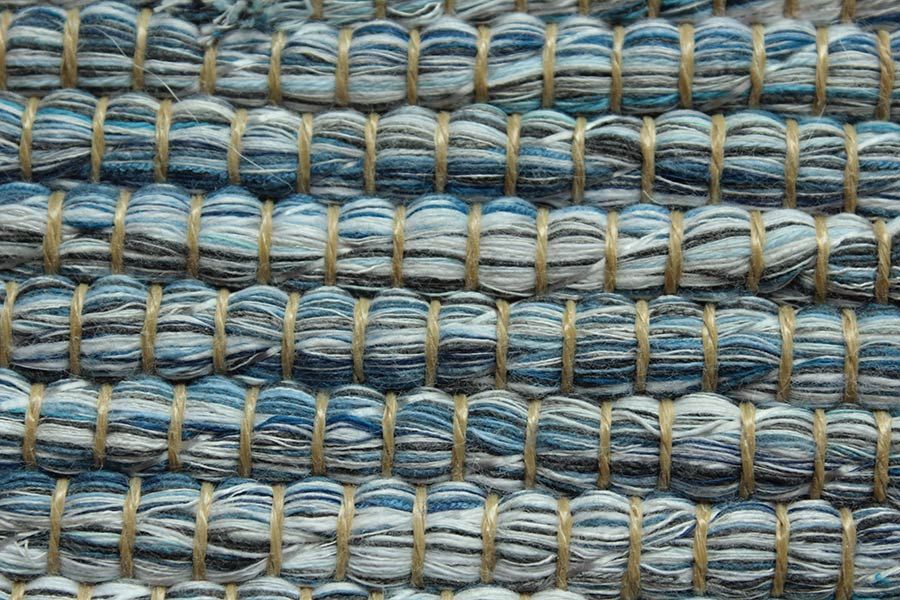 Eine Nahaufnahme eines blau-weißen Teppichs mit Streifenmuster.