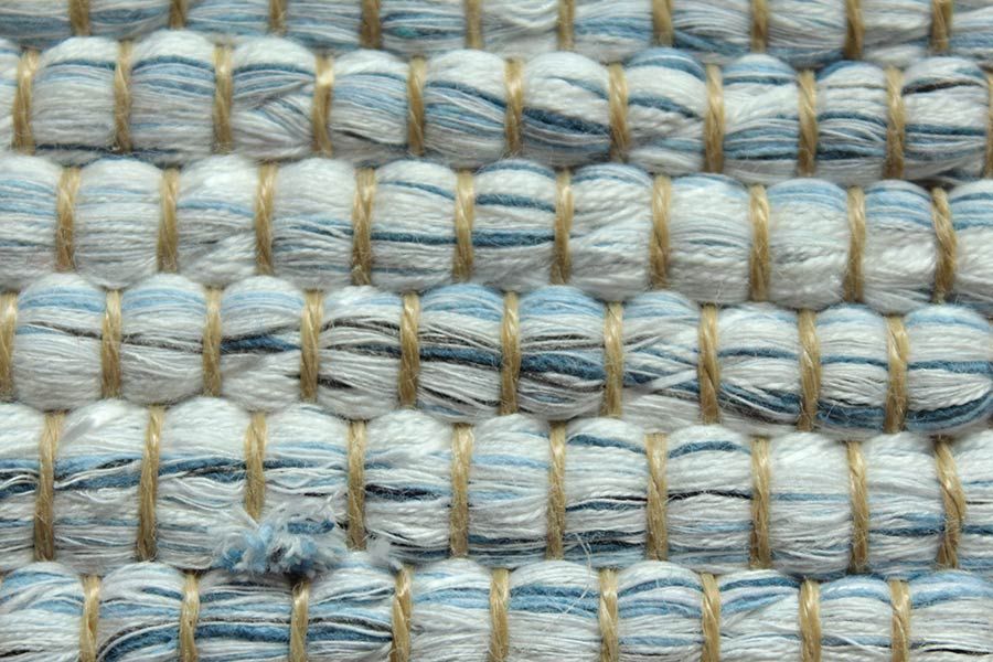Eine Nahaufnahme eines Teppichs mit blauem und weißem Garn.