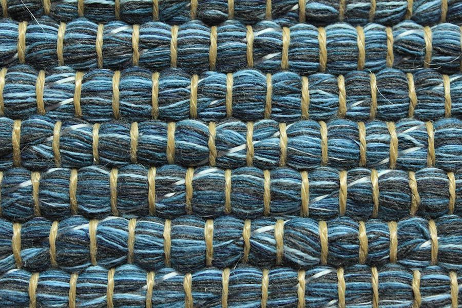 Eine Nahaufnahme eines blauen Teppichs mit goldenen Nähten