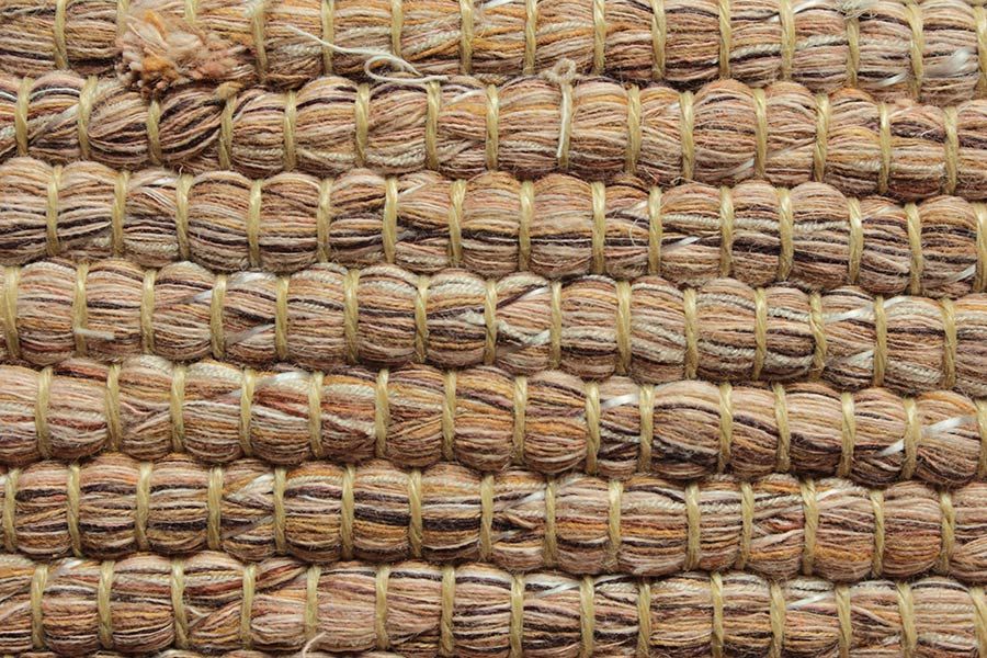 Eine Nahaufnahme eines Teppichs aus Stroh und Garn.