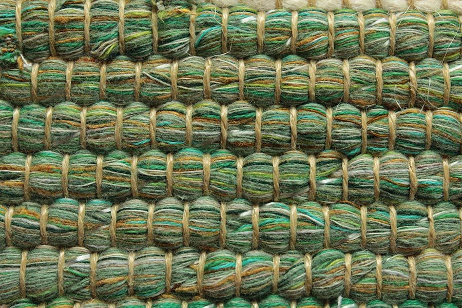 Eine Nahaufnahme eines grünen Teppichs mit Seilstruktur.