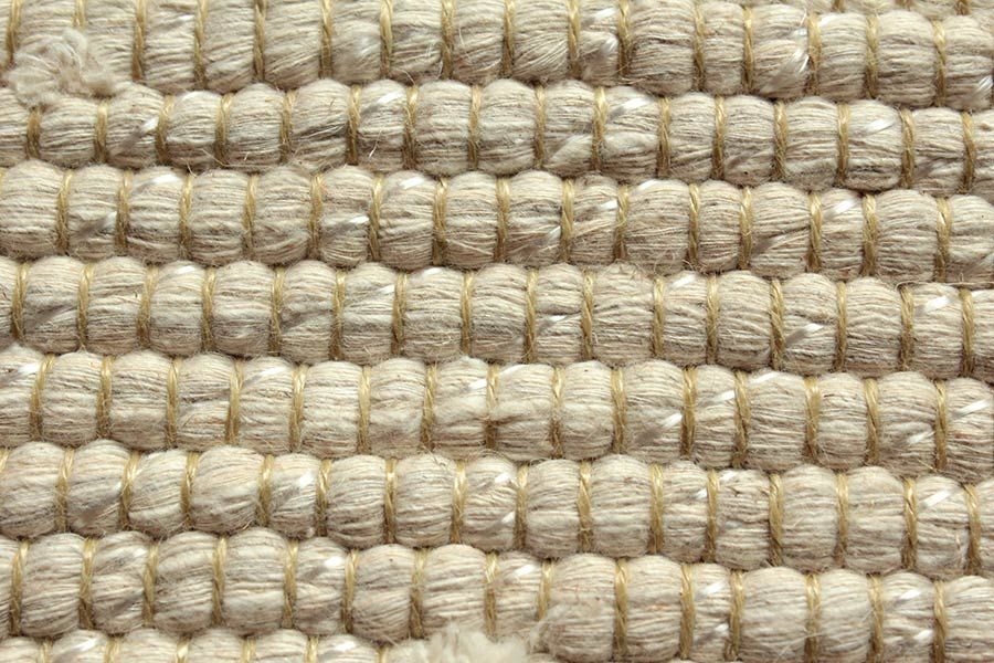 Eine Nahaufnahme eines weißen Teppichs mit Strickmuster.