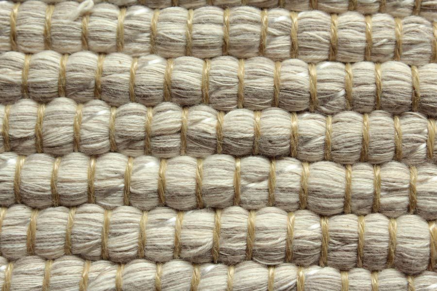 Eine Nahaufnahme eines weißen Teppichs mit Strickmuster.