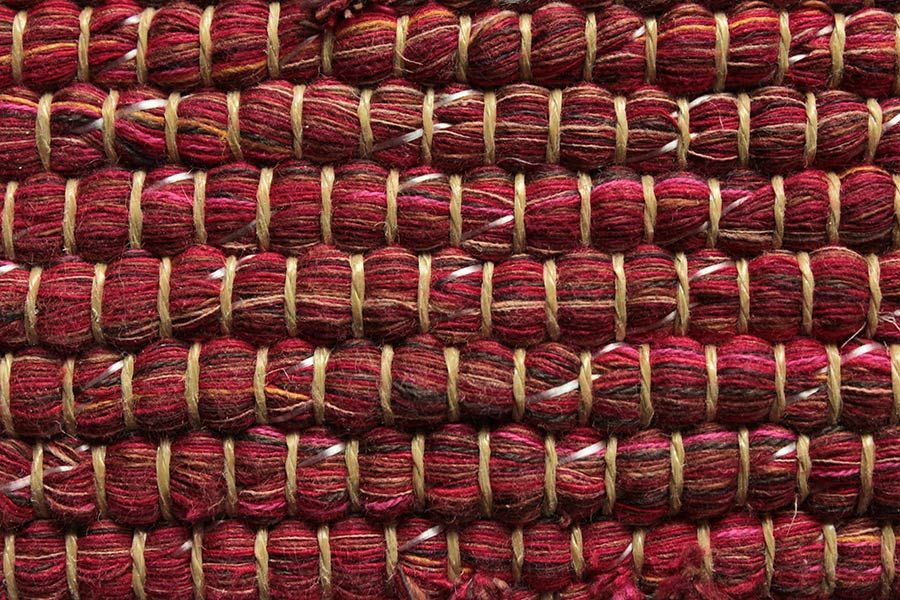 Eine Nahaufnahme eines roten Teppichs mit gewebtem Muster