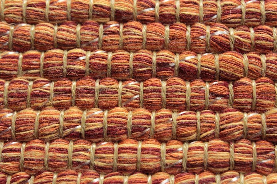 Eine Nahaufnahme eines gewebten Teppichs mit Streifenmuster.