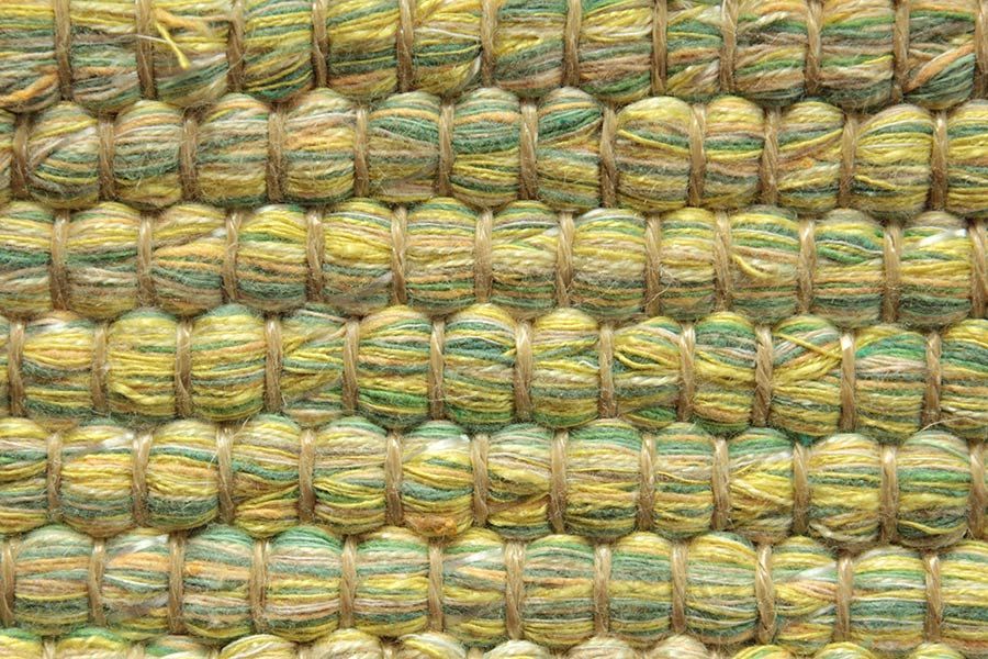 Eine Nahaufnahme eines gelb-grünen Teppichs.