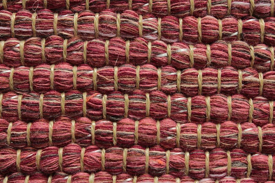 Eine Nahaufnahme eines roten Teppichs mit Korbrand.