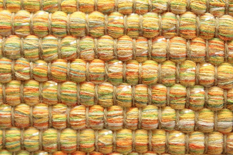 Eine Nahaufnahme eines bunten Teppichs mit vielen Perlen darauf.