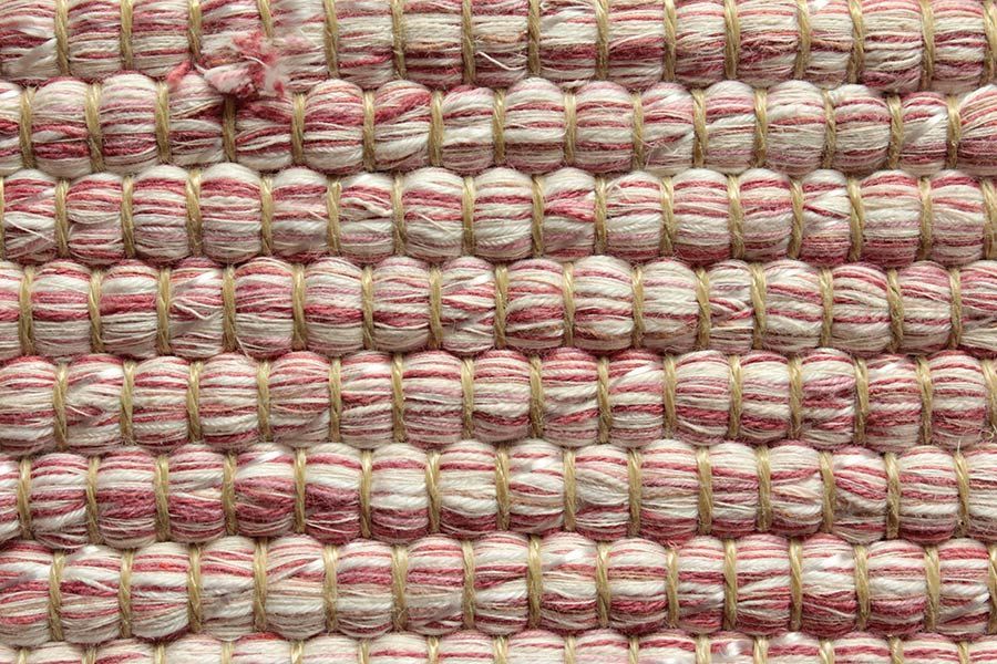 Eine Nahaufnahme eines rot-weißen Teppichs mit Streifenmuster.