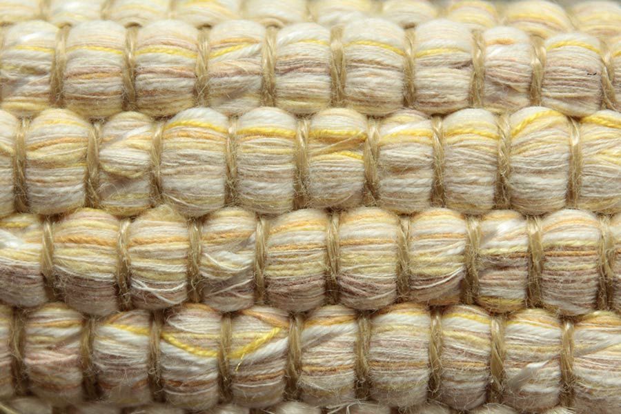 Eine Nahaufnahme eines Strickstoffes mit einem gelben Streifen.