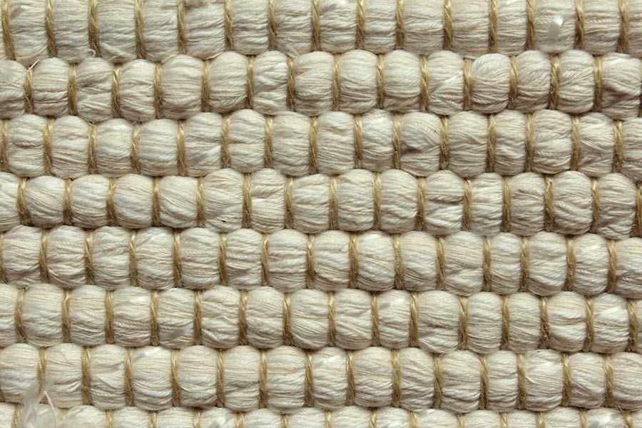 Eine Nahaufnahme eines weißen Teppichs mit Strickmuster.