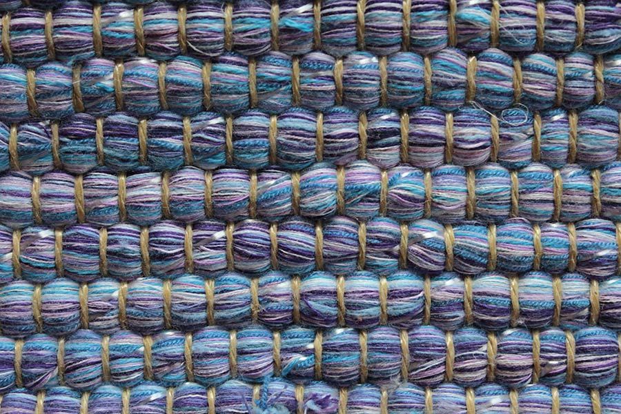 Eine Nahaufnahme eines blauen und violetten Teppichs.