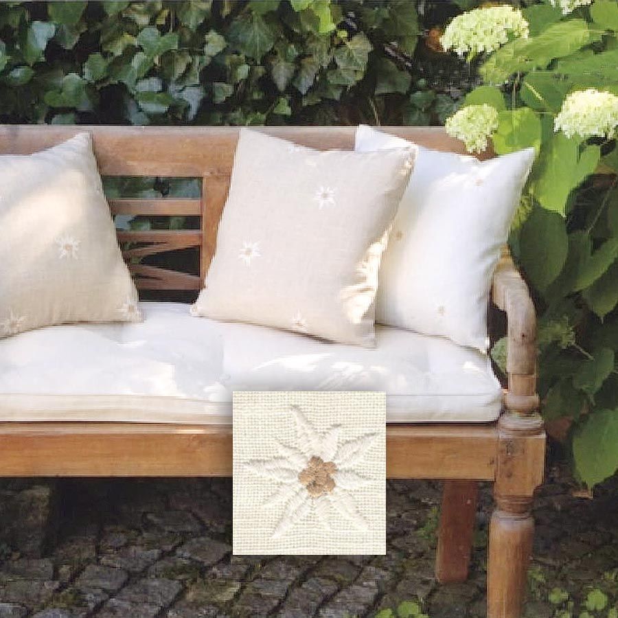 Eine Holzbank mit weißen Kissen darauf