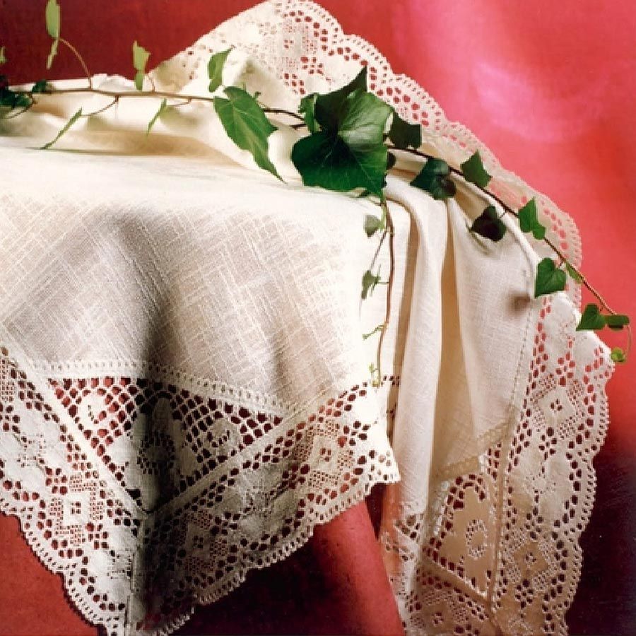 Eine Tischdecke mit Spitzenbesatz liegt auf einem Tisch