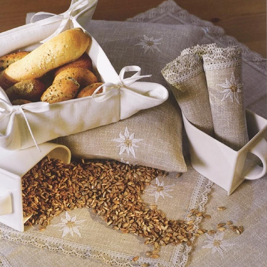 Ein Korb mit Brot steht auf einem Tisch neben einem Haufen Getreide