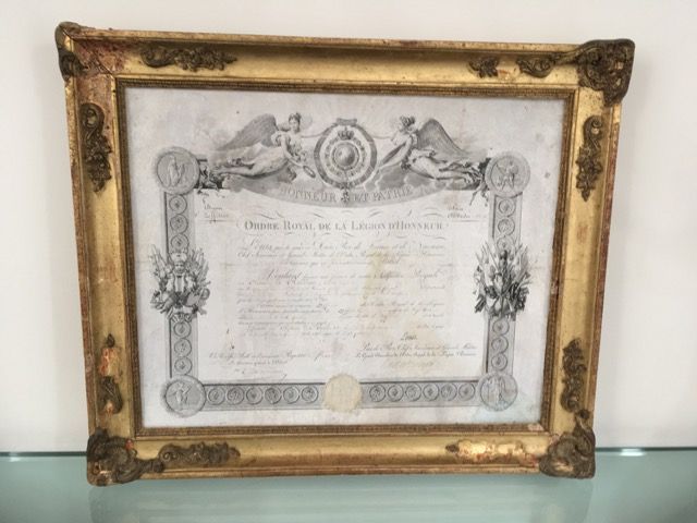 Un certificat ancien encadré de la Légion d'honneur, orné de dorures, sur fond blanc.