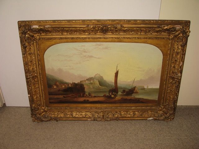 Un tableau de paysage encadré représentant un voilier près d'un village côtier au crépuscule, dans un cadre doré orné.