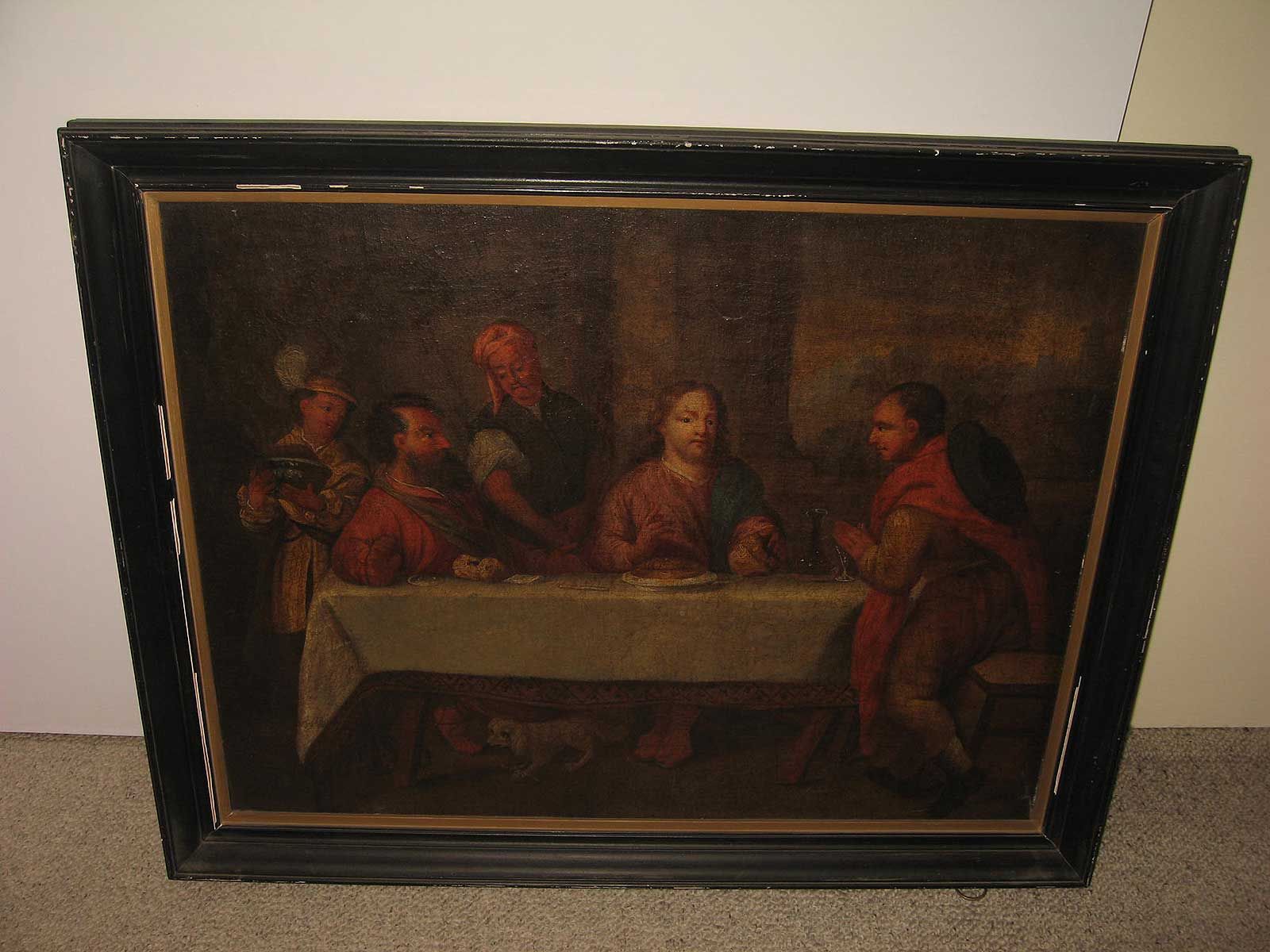 Peinture à l'huile représentant un groupe de personnes dînant à table, réalisée dans un style classique, faiblement éclairé, du XVIIe siècle, avec un cadre sombre.