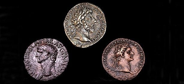 Trois pièces de monnaie romaines antiques disposées en triangle sur fond noir, chacune présentant un portrait de profil.