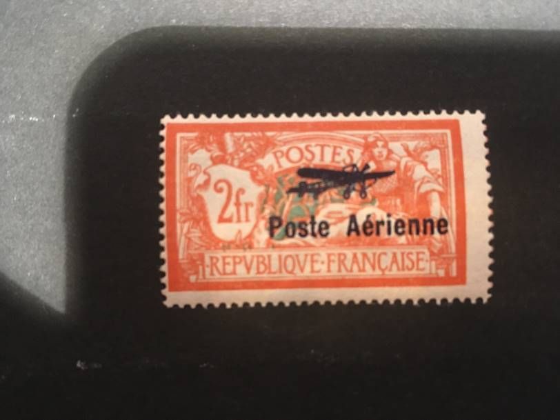 Un timbre-poste aérien français vintage de 2 francs, de couleur orange, représentant un avion surimprimé et portant la mention « Poste Aérienne ».