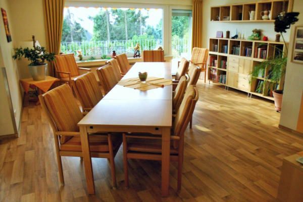 Ein Esszimmer mit einem langen Tisch und Stühlen