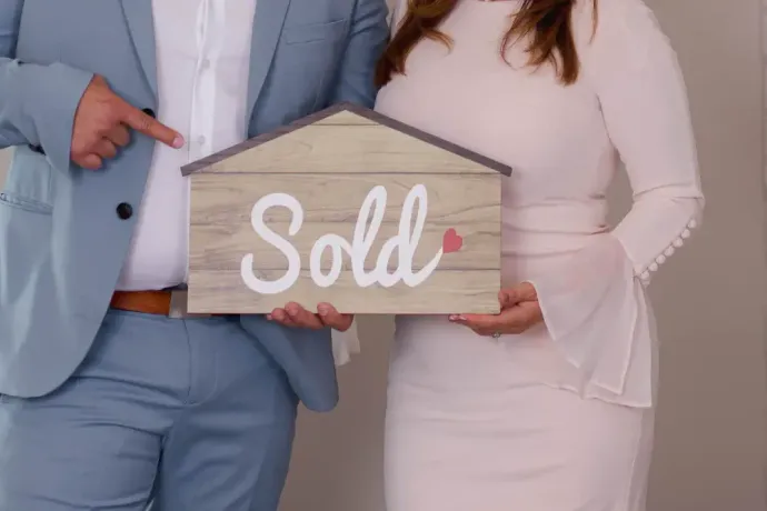 Casal segurando uma placa de 