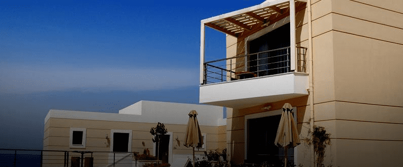 Una casa grande con balcón con vista al mar.