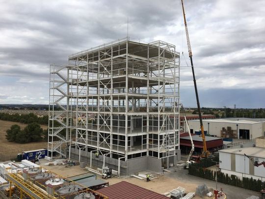 Un gran edificio en construcción con una grúa en primer plano.
