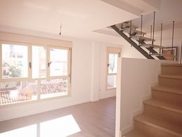Una habitación vacía con escaleras que conducen al segundo piso.