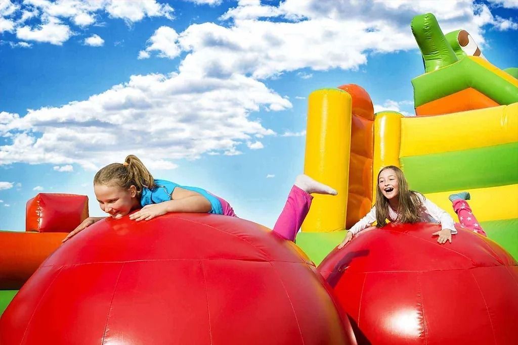 Dos niñas están jugando en una casa inflable.