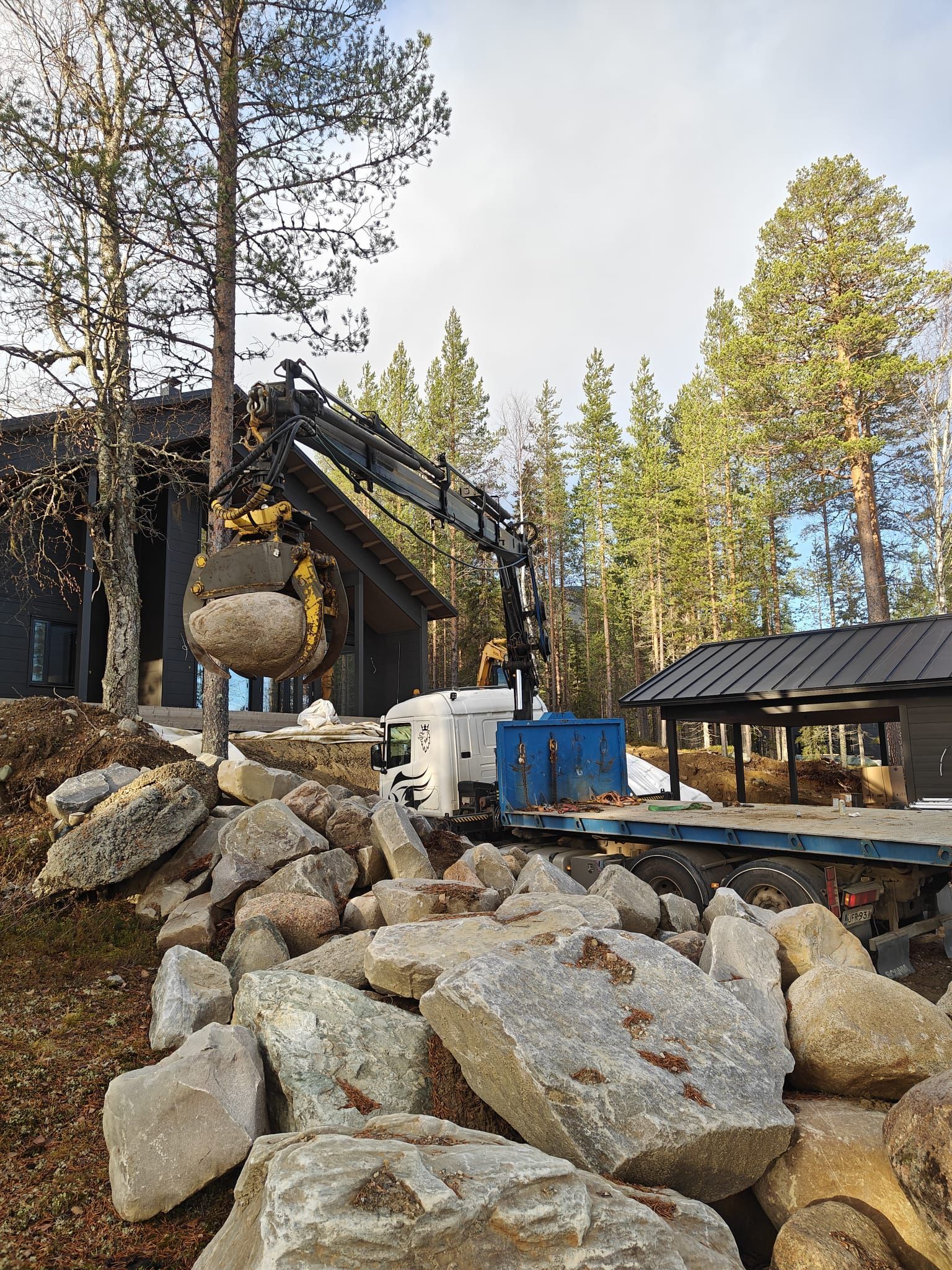 Piharakentaminen ja suurten kivien siirto Hiab-nosturilla. Viimeistellyt pihatyöt ja maisemointi Lapin alueella.