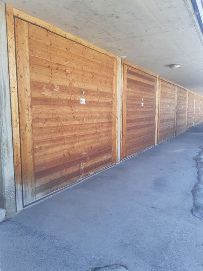 Porte d'entrée blanche avec fenêtres latérales encastrées dans un mur extérieur beige