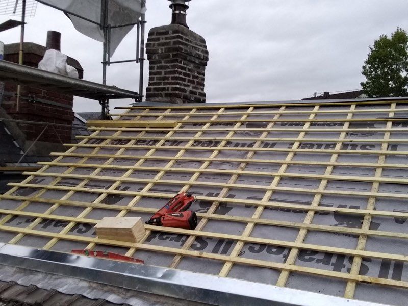 Artisan installant des tuiles sur un toit